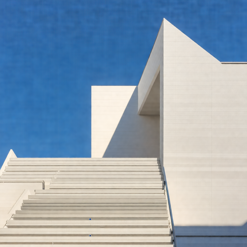 Large white building with a staircase leading up to the e...