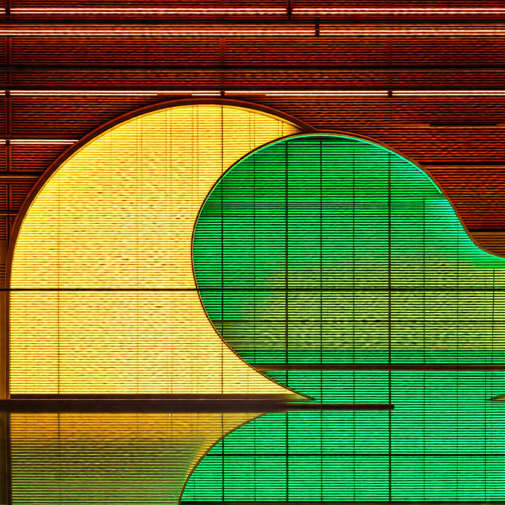 Large, curved glass building with a yellow and green colo...