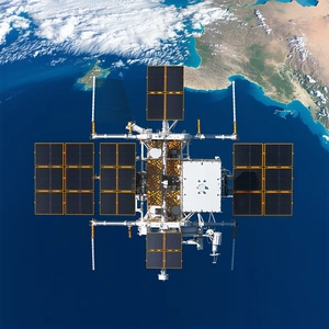 A Large Satellite Floating In The Sky Above The Ocean