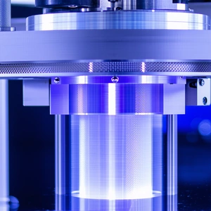A Large, Clear Glass Cylinder With A Blue Light Inside
