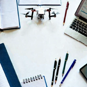 Business Drone Photography: Workplace With Notebooks And Pens On Desk With Small Drone