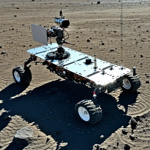 A Large, Silver Robotic Vehicle With A Camera Mounted On Top Of It