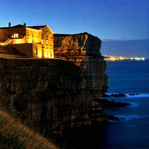 Nature Architectural Photography: Coastal Cliff During Night With Large, Building