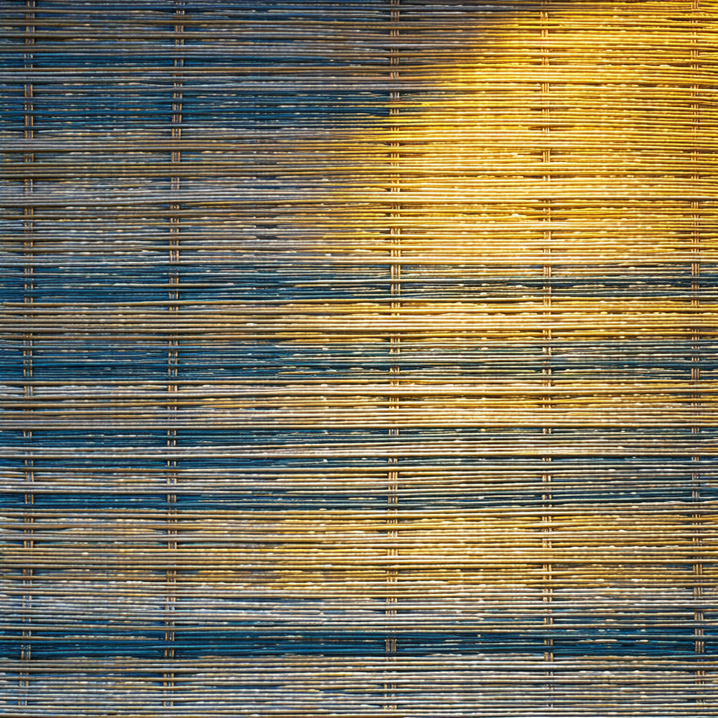Blue and yellow woven fabric with a yellow light shining ...