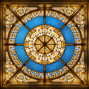 Large, ornate stained glass window with a blue background