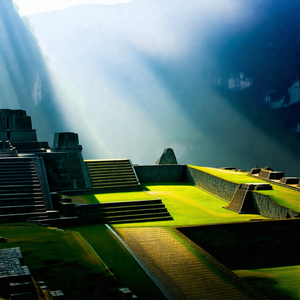 Large, ancient stone structure with a lush green field su...